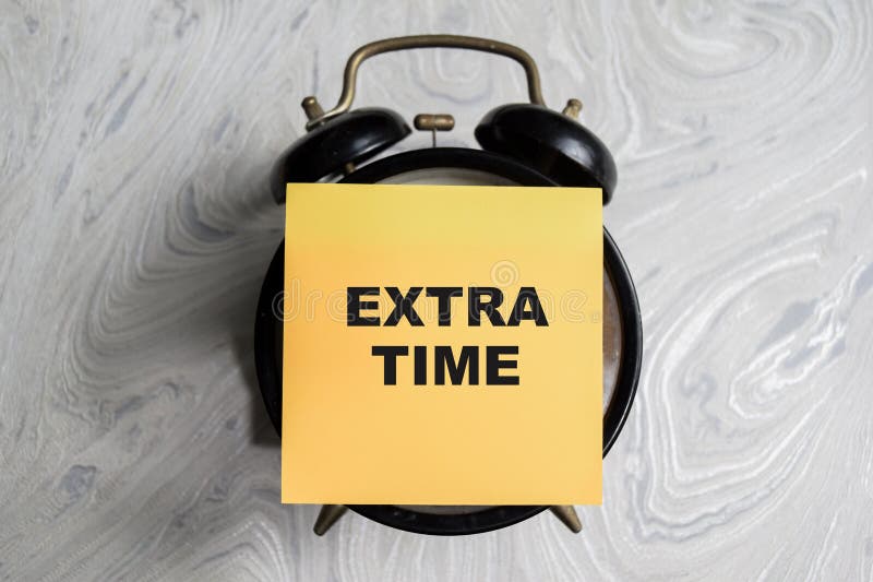 Concept of Extra time write on sticky notes isolated on Wooden Table stock photos