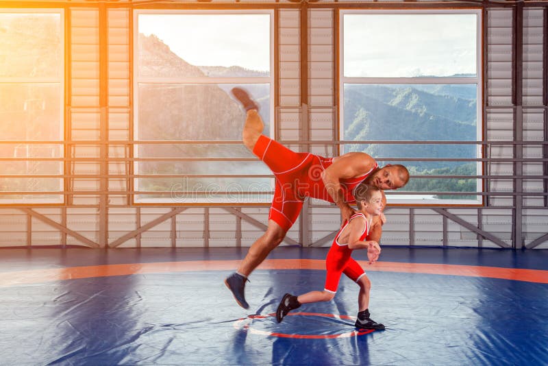 Two men in sports wrestling tights and wrestling during a traditional  Greco-Roman wrestling in fight on a wrestling mat. Wrestler throws his  opponent's chest through Photos