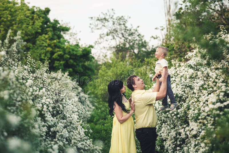 Concept gelukkige familie De papa heft omhoog zijn kleine zoonshoogte met zijn handen op stock afbeelding Concept gelukkige familie De papa heft omhoog zijn kleine zoonshoogte met zijn handen op stock afbeelding