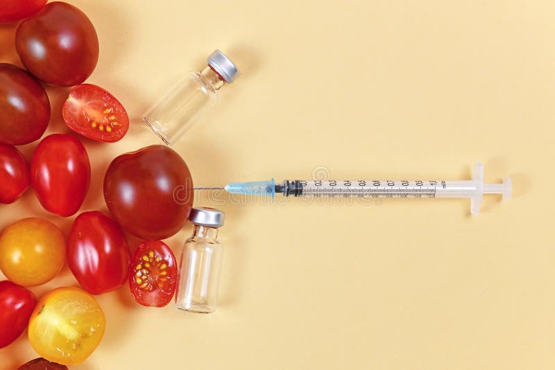 Geneticky upravené jedlo paradajky, striekačka a prázdny zdravotné fľaštičky na.