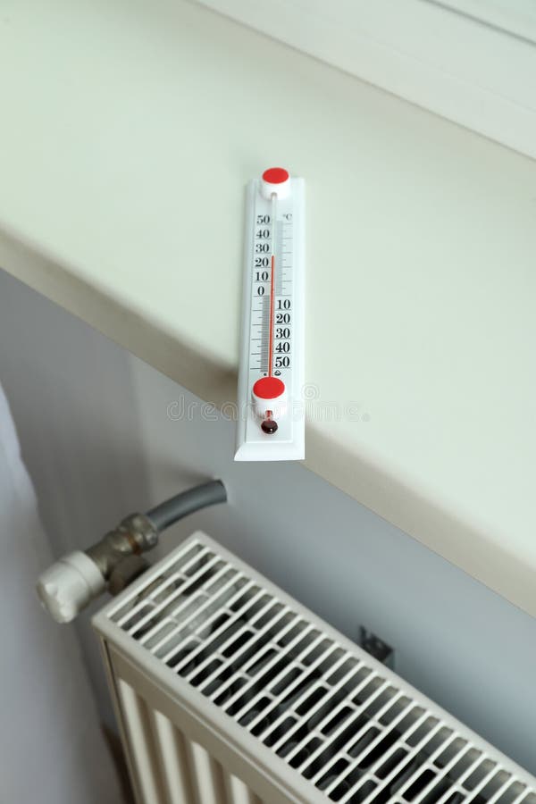 Concept of Heating Season with Thermometer on Windowsill Stock Photo