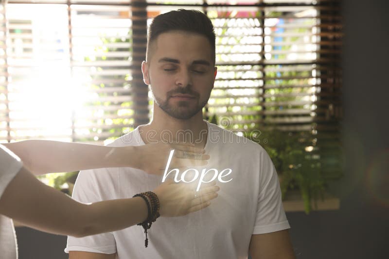 Concept of hope. Young man during healing session royalty free stock photography