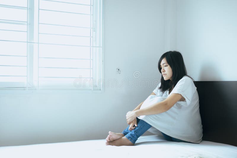 Concept inattendu de grossesse, femme asiatique s'asseyant sur la chambre à coucher à la maison, famille malheureuse et confuse d photos stock Concept inattendu de grossesse, femme asiatique s'asseyant sur la chambre à coucher à la maison, famille malheureuse et confuse d photos stock