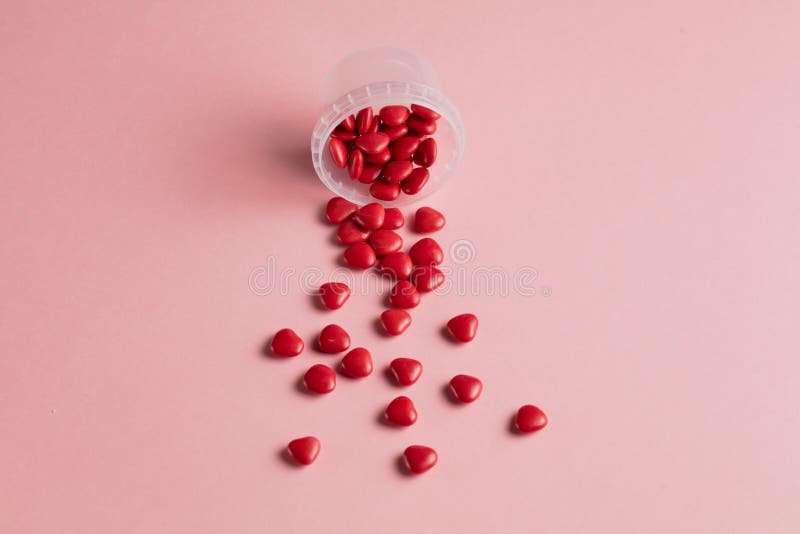 Concept minimal petits coeurs rouges avec la bouteille en verre ouverte sur le fond rose photographie stock libre de droits Concept minimal petits coeurs rouges avec la bouteille en verre ouverte sur le fond rose photographie stock libre de droits