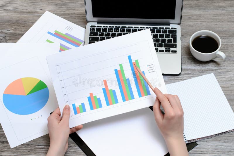 Concept of office workplace. Hands holding the results of sales represented on the graphics, best achievement , profit progress ea stock image