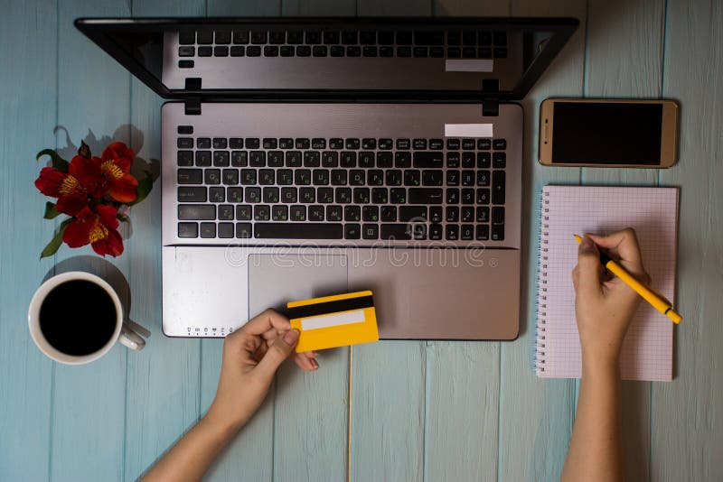 Concept of online new technologies, shopping buy goods. woman buying with debit credit card and laptop in cafe. Top view. Flat lay royalty free stock photos Concept of online new technologies, shopping buy goods. woman buying with debit credit card and laptop in cafe. Top view. Flat lay royalty free stock photos
