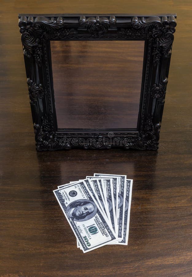 Money without reflection in front of a mirror. Both objects are lying on a wooden table. Money without reflection in front of a mirror. Both objects are lying on a wooden table.