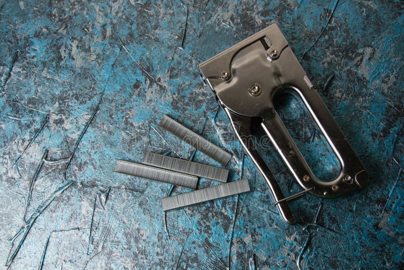 The Concept of Repair and Construction. Construction Stapler with Staples on a Background of