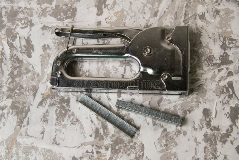 The Concept of Repair and Construction. Construction Stapler with Staples on a Background of