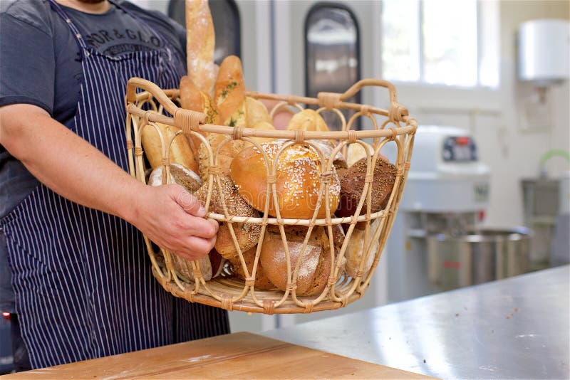 Baker Holding Basket of Bread in the Kitchen of the Bakery Stock Image