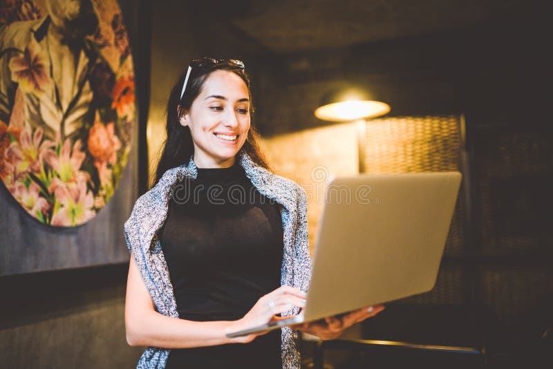 The concept of small business and technology. Young beautiful brunette businesswoman in black dress and gray sweater stands in royalty free stock photos The concept of small business and technology. Young beautiful brunette businesswoman in black dress and gray sweater stands in royalty free stock photos