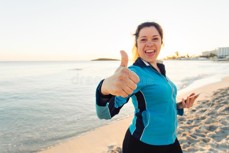 Concept of sport, fitness, healthy lifestyle and running - Motivated sporty woman doing thumbs up success gesture after