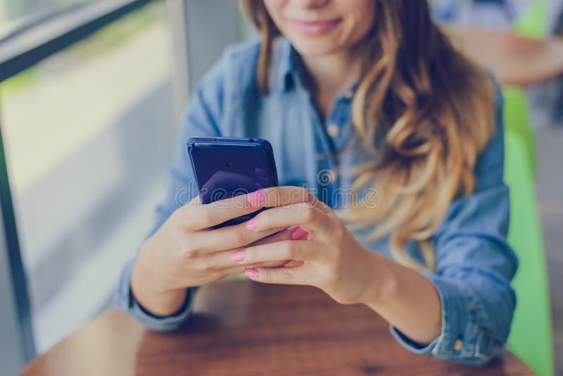 Concept of using modern technology for shopping. Happy smiling woman is using mobile phone for internet shopping, she is making pu