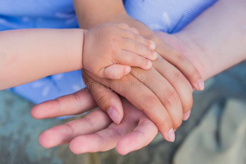 Concept van eenheid, steun, bescherming, geluk. Kinderhandje in ouders. Handen van vader, moeder, hou kleine handje stock afbeelding Concept van eenheid, steun, bescherming, geluk. Kinderhandje in ouders. Handen van vader, moeder, hou kleine handje stock afbeelding