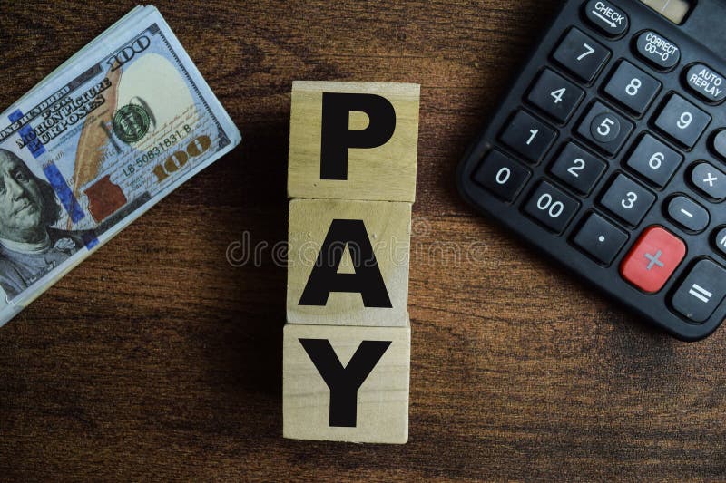 Concept of The wooden Cubes with the word Pay on wooden background stock images