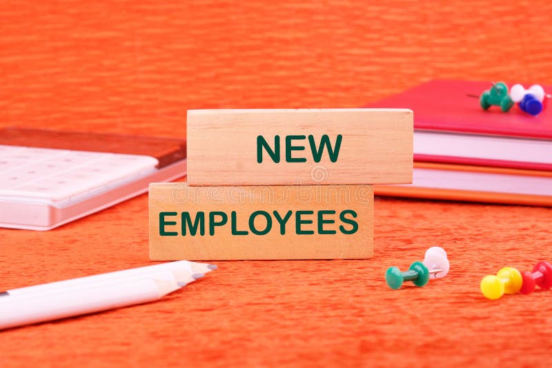 Concept words NEW EMPLOYEES on wooden blocks in front of an orange background royalty free stock photo