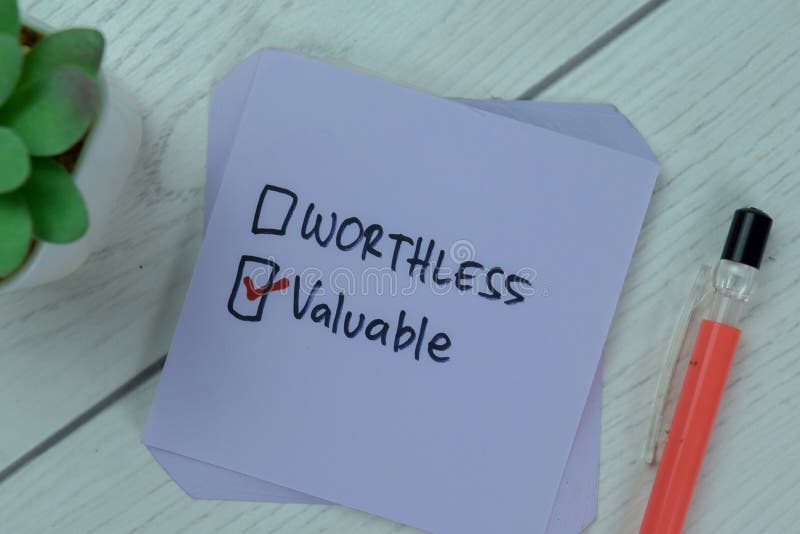 Concept of Worthless or Valuable? Valuable write on sticky notes isolated on Wooden Table stock photos
