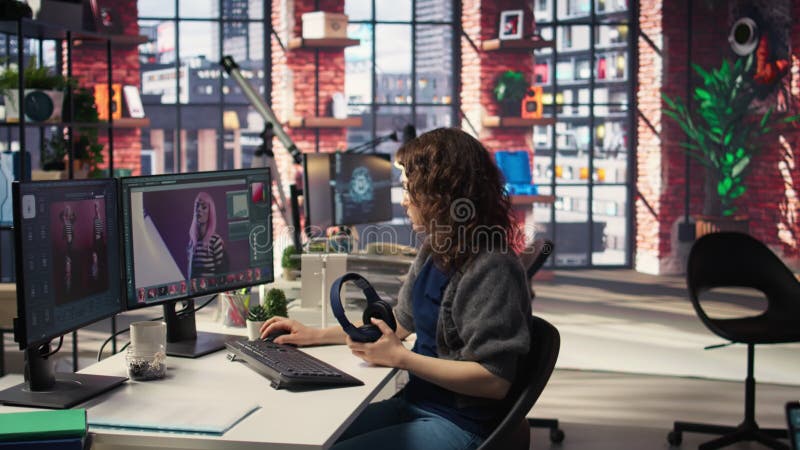Concepteur de rédacteurs en chef femme retouche les photos sur le bureau à deux écrans banque de vidéos