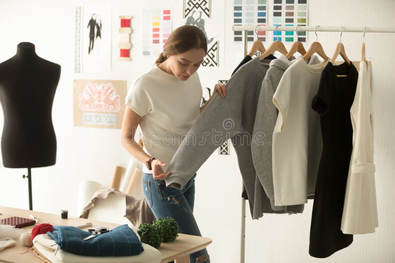 Concepteur de vêtements féminin travaillant avec le nouvel usage de femme dans l'atelier images libres de droits Concepteur de vêtements féminin travaillant avec le nouvel usage de femme dans l'atelier images libres de droits