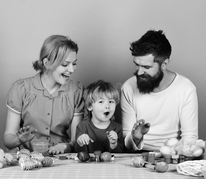 Concepto alegre de la familia y de la celebración Hombre con la barba, mujer e hijo felices junto La familia prepara los huevos c fotos de archivo libres de regalías Concepto alegre de la familia y de la celebración Hombre con la barba, mujer e hijo felices junto La familia prepara los huevos c fotos de archivo libres de regalías