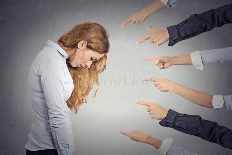 Concept of accusation of guilty businesswoman. Side profile portrait sad upset woman looking down many fingers pointing at her grey office background. Human face expression emotion feeling. Concept of accusation of guilty businesswoman. Side profile portrait sad upset woman looking down many fingers pointing at her grey office background. Human face expression emotion feeling