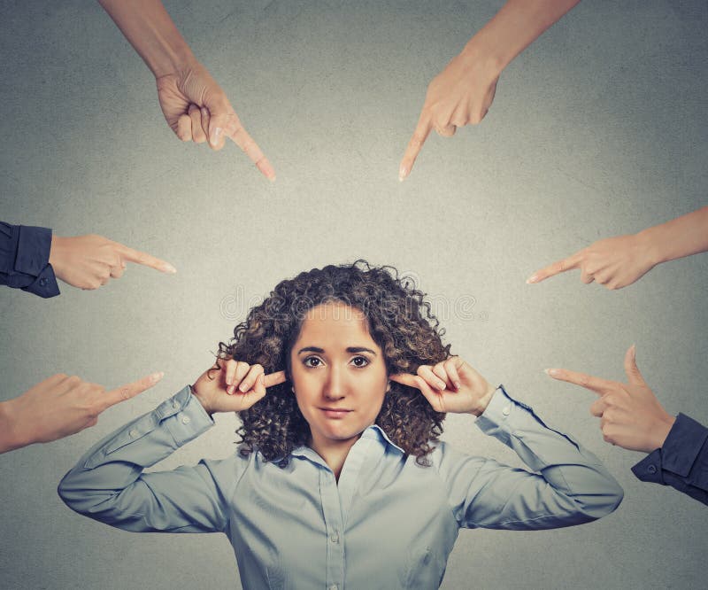 Concept of accusation of guilty businesswoman. Portrait unhappy sad upset woman plugging her ears many fingers pointing at her grey office background. Human face expression emotion feeling. Concept of accusation of guilty businesswoman. Portrait unhappy sad upset woman plugging her ears many fingers pointing at her grey office background. Human face expression emotion feeling