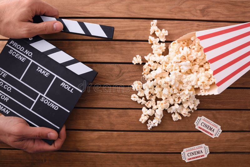 Concepto de cine de observación con la mano con clapperboard y popco fotografía de archivo libre de regalías Concepto de cine de observación con la mano con clapperboard y popco fotografía de archivo libre de regalías