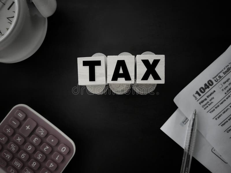 Concepto de cobro de impuestos - Palabras fiscales en bloques de madera con la U S IRS 1040 forma, pluma, monedas, calculadora y imagen de archivo Concepto de cobro de impuestos - Palabras fiscales en bloques de madera con la U S IRS 1040 forma, pluma, monedas, calculadora y imagen de archivo