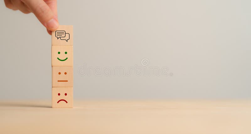 Concepto de comentarios del cliente. Colocar bloques de madera con caras emoticonas que representen expresiones tristes, neutras y imagen de archivo
