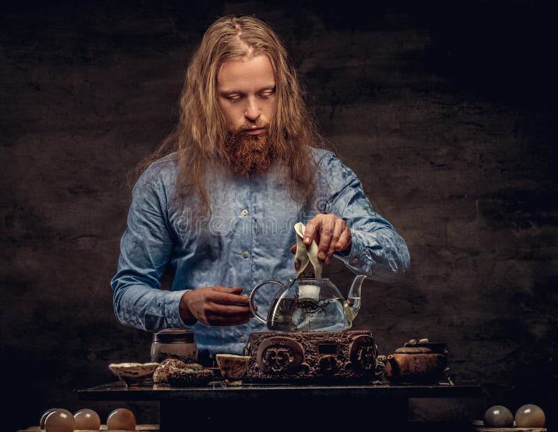 Concepto de la ceremonia de té El retrato de un varón del inconformista del pelirrojo con el pelo largo y la barba llena se visti foto de archivo libre de regalías Concepto de la ceremonia de té El retrato de un varón del inconformista del pelirrojo con el pelo largo y la barba llena se visti foto de archivo libre de regalías