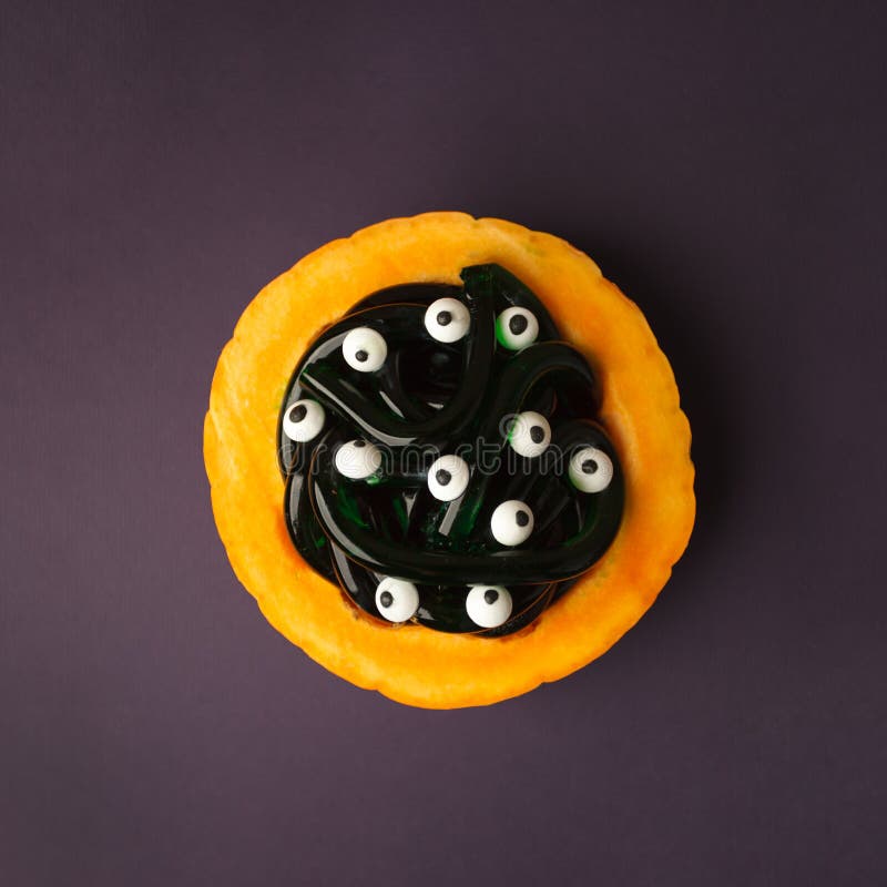 Concepto de la comida, del partido y de los días de fiesta - platee la calabaza con los caramelos gomosos de los gusanos y los oj imagen de archivo Concepto de la comida, del partido y de los días de fiesta - platee la calabaza con los caramelos gomosos de los gusanos y los oj imagen de archivo