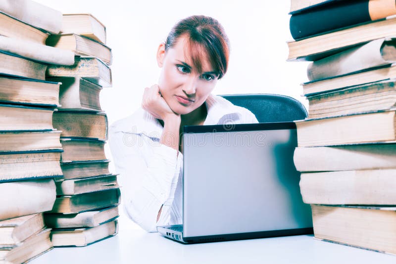 Concepto de la educación Mujer joven hermosa con la pila de libros con su ordenador portátil en el fondo blanco fotografía de archivo Concepto de la educación Mujer joven hermosa con la pila de libros con su ordenador portátil en el fondo blanco fotografía de archivo