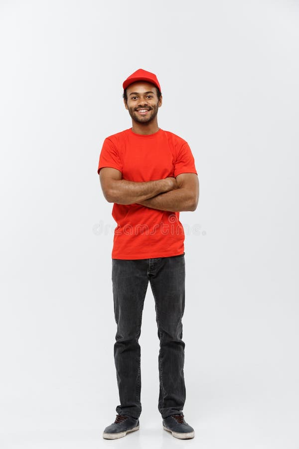 Concepto de la entrega - el hombre de entrega afroamericano hermoso cruzó los brazos encima aislados en fondo gris del estudio co imagenes de archivo Concepto de la entrega - el hombre de entrega afroamericano hermoso cruzó los brazos encima aislados en fondo gris del estudio co imagenes de archivo
