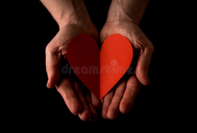 Concepto de la mano amiga, palmas de las manos del hombre encima de llevar a cabo un corazón rojo, dando el amor, alcanzando haci