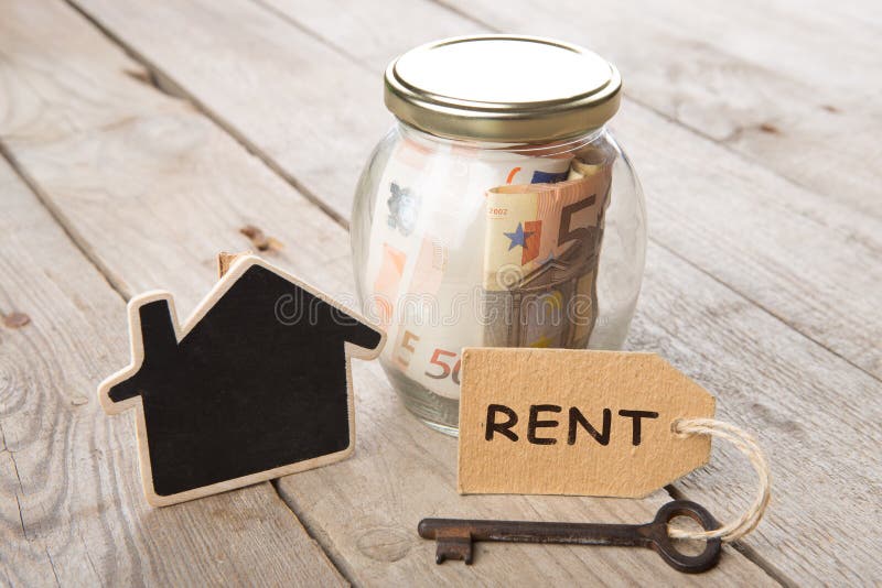 Concepto de las finanzas de las propiedades inmobiliarias - vidrio del dinero con palabra del alquiler imagen de archivo Concepto de las finanzas de las propiedades inmobiliarias - vidrio del dinero con palabra del alquiler imagen de archivo