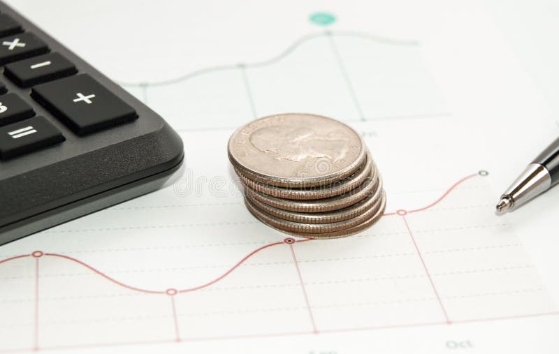 Concepto de negocio y finanzas: Monedas de oro apiladas, calculadora, pluma en gráfico fotografía de archivo libre de regalías