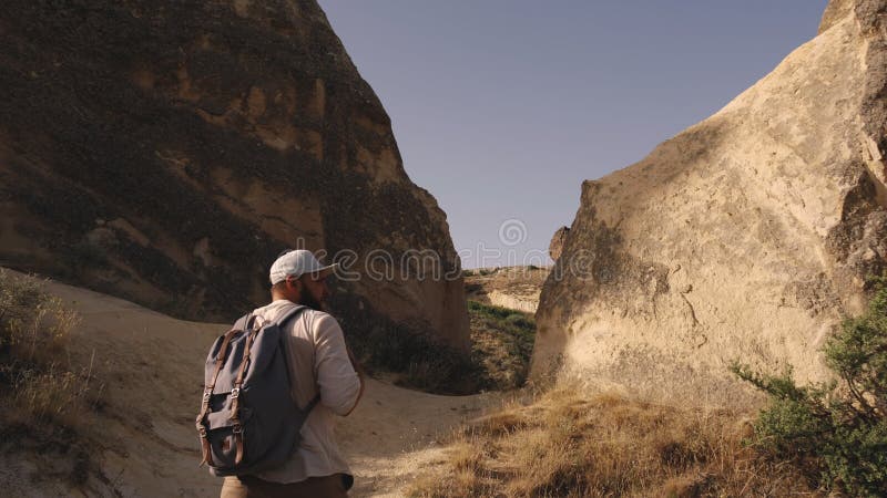 Concepto de wanderlust. atractivo joven turista haciendo senderismo solo con mochila explorando montañas en el pavo de capadocia