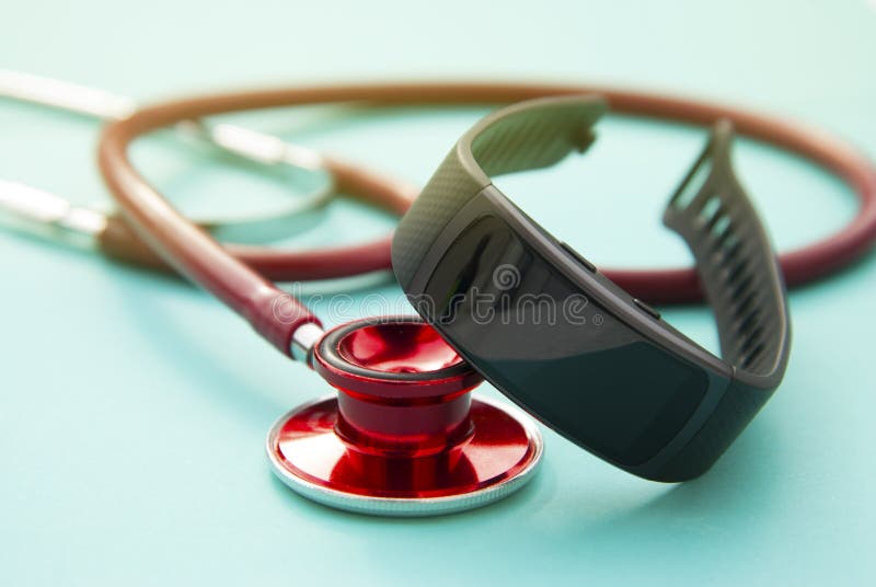 Concepto del cuidado médico Perseguidor y sthetoscop de la actividad del reloj de la aptitud sobre fondo azul primer, foco select foto de archivo Concepto del cuidado médico Perseguidor y sthetoscop de la actividad del reloj de la aptitud sobre fondo azul primer, foco select foto de archivo