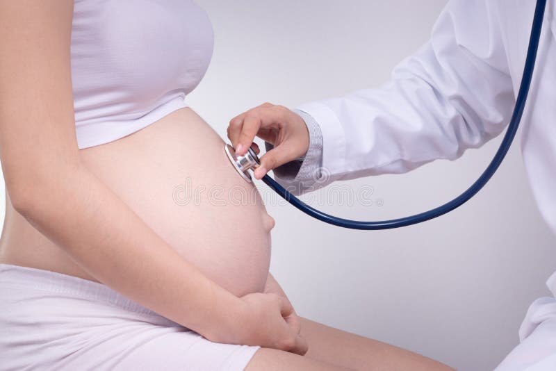 Concepto del embarazo, de la maternidad, de la gente, de la medicina y de la fertilidad - mujer embarazada feliz con el doctor en foto de archivo libre de regalías Concepto del embarazo, de la maternidad, de la gente, de la medicina y de la fertilidad - mujer embarazada feliz con el doctor en foto de archivo libre de regalías