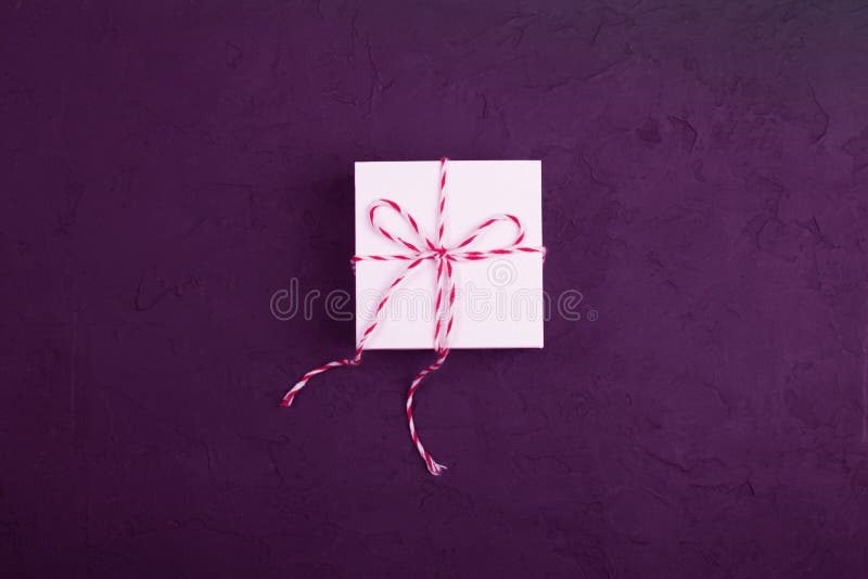 Concepto del regalo de Navidad - la caja de regalo blanca con guita acuñó encendido foto de archivo Concepto del regalo de Navidad - la caja de regalo blanca con guita acuñó encendido foto de archivo