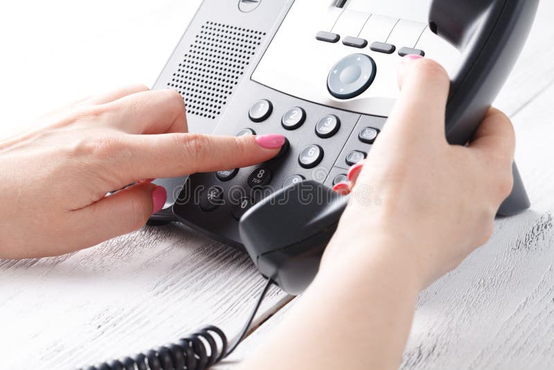 Concepto del teléfono del centro de atención telefónica o de la oficina, número femenino de la prensa del finger en phonepad fotos de archivo libres de regalías Concepto del teléfono del centro de atención telefónica o de la oficina, número femenino de la prensa del finger en phonepad fotos de archivo libres de regalías