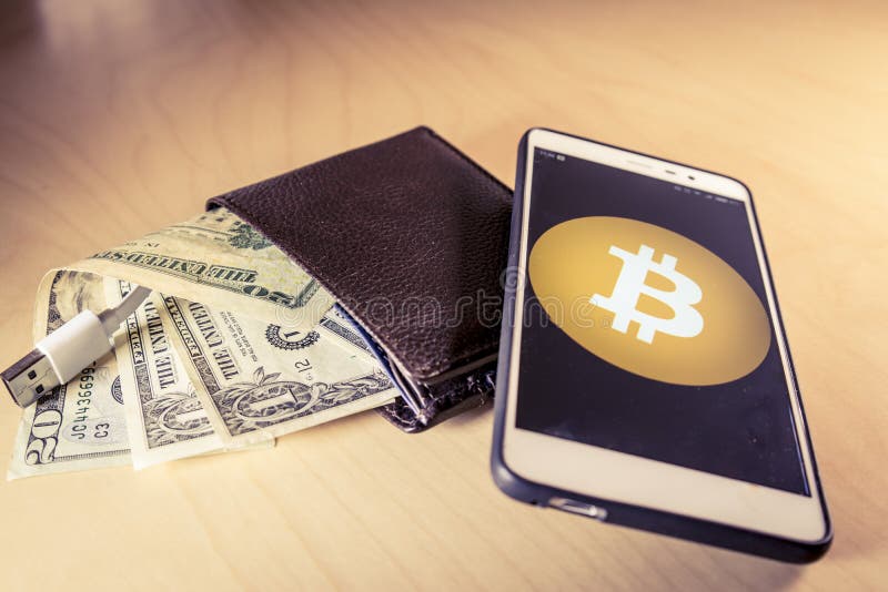 Concepto financiero con una cartera con los dólares de EE. UU., el cable del USB y el smartphone con el logotipo del bitcoin fotografía de archivo libre de regalías Concepto financiero con una cartera con los dólares de EE. UU., el cable del USB y el smartphone con el logotipo del bitcoin fotografía de archivo libre de regalías
