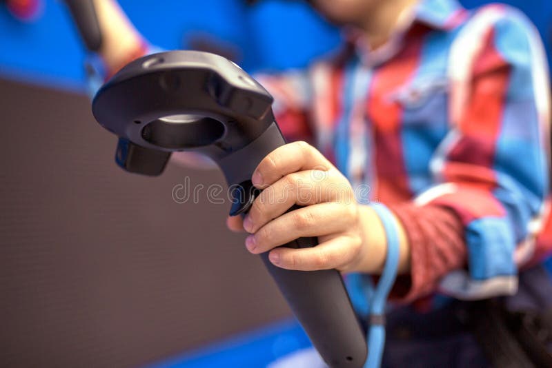 Concepto moderno de la tecnología, del juego y de la gente - muchacho en las auriculares de la realidad virtual o los vidrios 3d que juegan el videojuego
