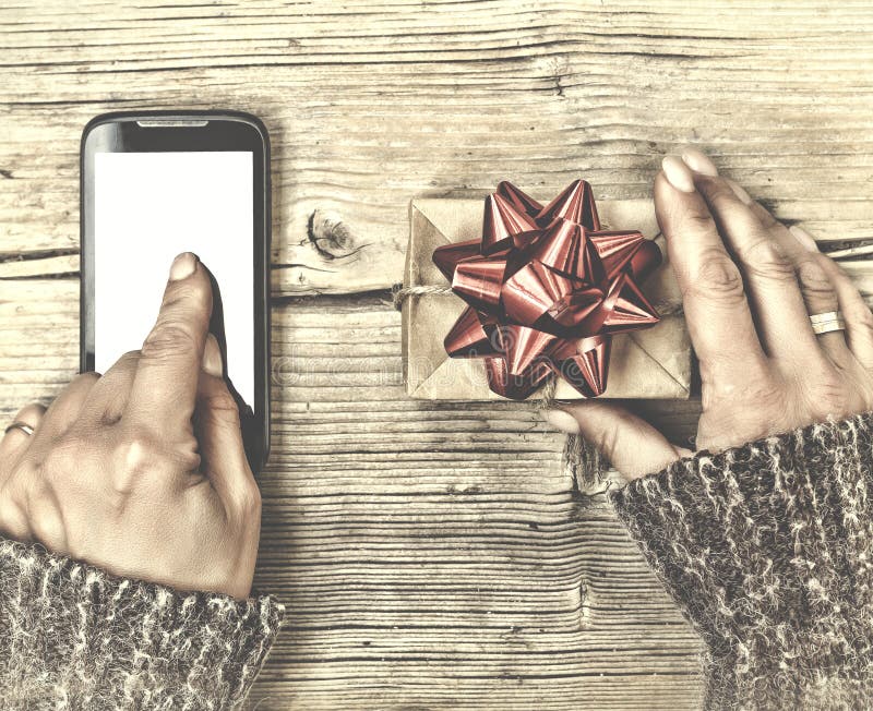 Concepto: Regalos de la Navidad Una persona envía o pide un regalo de la Navidad usando un smartphone Entrega de Internet imagenes de archivo Concepto: Regalos de la Navidad Una persona envía o pide un regalo de la Navidad usando un smartphone Entrega de Internet imagenes de archivo