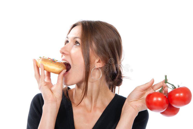 Healthy eating food concept. Woman comparing unhealthy donut and organic red tomatoes, thinking isolated on a white background. Healthy eating food concept. Woman comparing unhealthy donut and organic red tomatoes, thinking isolated on a white background