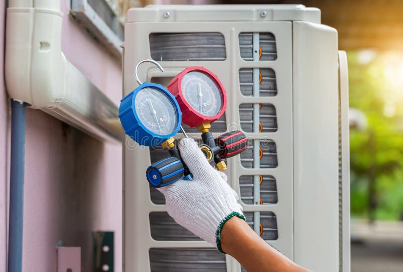 Conceptos de reparación del aire acondicionado técnico que sostiene el conjunto de manómetros del colector refrigerante herramient
