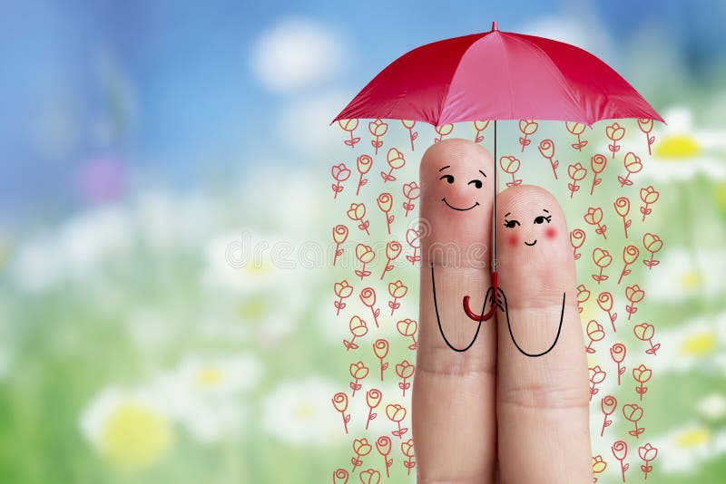 Conceptual finger art. Lovers are embracing and holding umbrella with falling flowers. Stock Image
