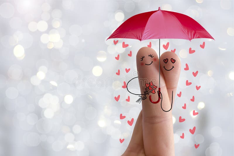 Conceptual finger art. Lovers are embracing and holding umbrella with falling hearts. Stock Image