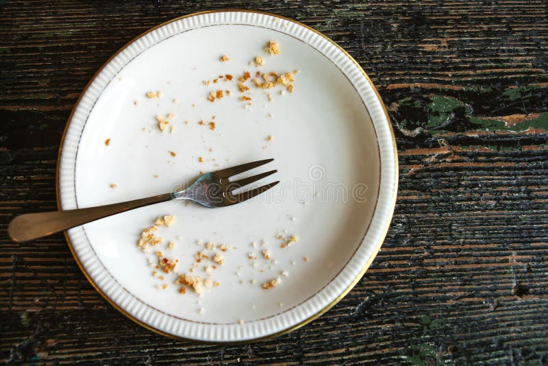 Conceptual image of the end of the holiday is an empty plate with crumbs and a fork on it.