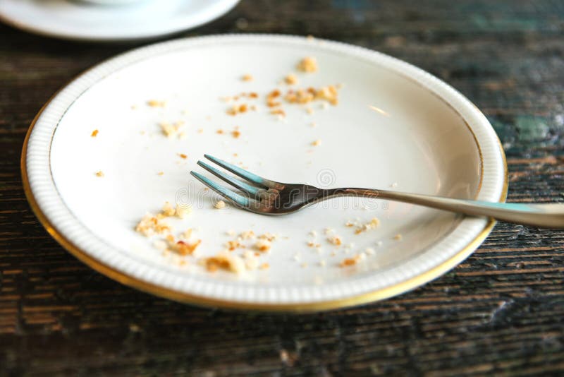 Conceptual image of the end of the holiday is an empty plate with crumbs and a fork on it.